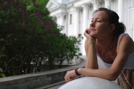 young woman relexing on  in front of  a park, St. Petersburg, Russia