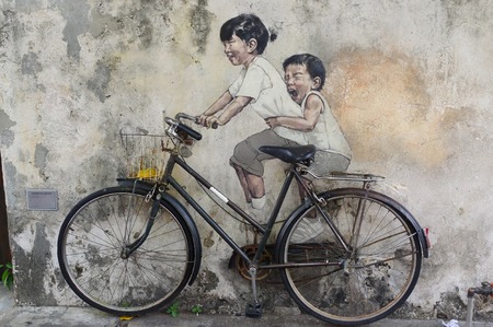 George Town, Penang, Malaysia - April 18, 2016: Little Children on a Bicycle street art mural by Lithuanian artist Ernest Zacharevic in Georgetown, Penang in Malaysia.のeditorial素材