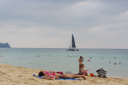family enjoy sunbathe on white sand beach on Phuket island in Thailandのeditorial素材