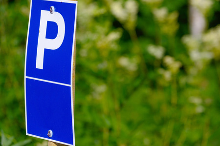 a blue parking sign with a big P on it on green backgroundのeditorial素材