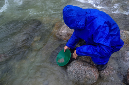 a man panning gold in a river with a sluice boxの写真素材
