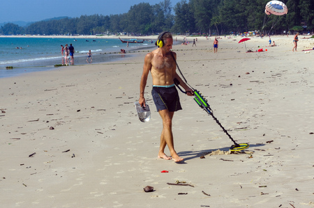 a treasure hunter with Metal detector on the beachの写真素材