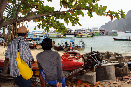 the main pier of the tropical thai island named Phi Phi, with a lot of colorful longtail boats in Thailandの写真素材