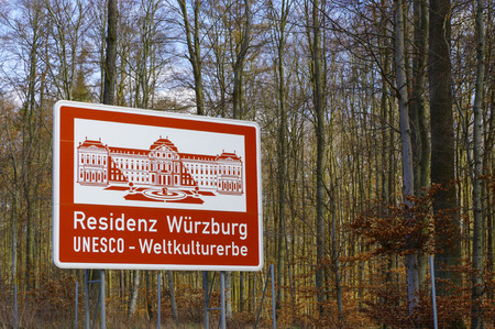 a red highway sign with a ilustration of historic place in Bavaria, Germany, part of the UNESCO World Heritage Site - Residenz Wuerzburg UNESCO Kulturerbe - in Germanのeditorial素材