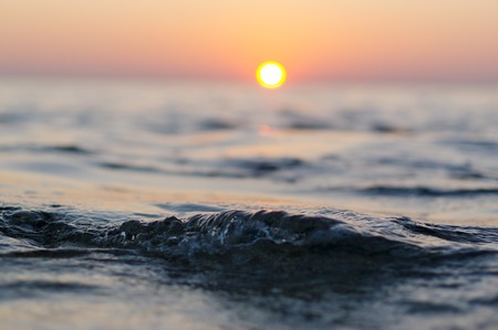 sea wave closeup at sunset time with red and orange sun reflection on the water. nature abstract...