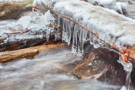 icicles over frozen waterの写真素材