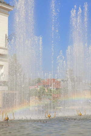 Rainbow in a city fountainの写真素材