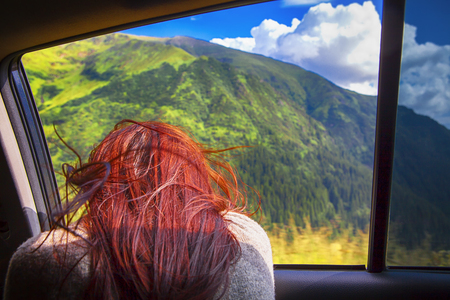 girl looking through the car windowの写真素材