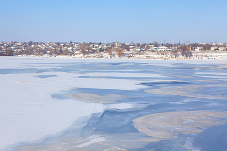 winter landscape with village and frozen lakeの写真素材
