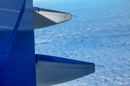 airplane flying above blue cloudsの写真素材