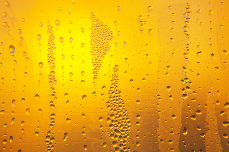 water drops on the glass surface, transparent yellow backgroundの写真素材