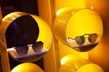 stylish glasses on yellow background on the showcaseの写真素材