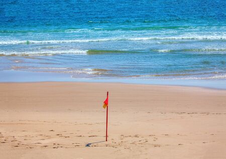 Warning flag on the sandy beachの写真素材