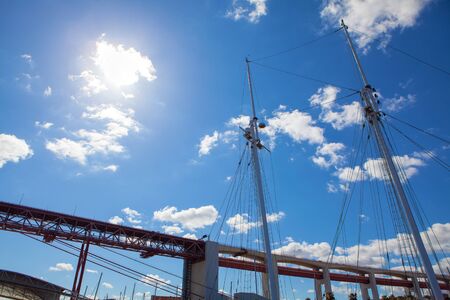 view of masts in the harbour and bridge against blue skyの写真素材
