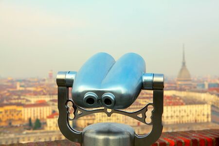 Looking at Turin city through tourist binocularsの写真素材