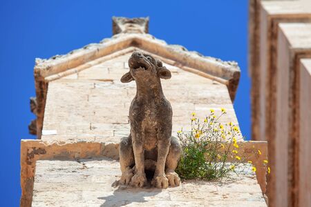 architectural gargoyle and natural flowersの写真素材