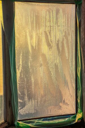 old window covered by transparent plastic