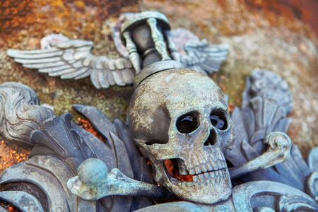 skull carved in stone on a graveの写真素材