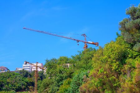 view of industrial cranes and building at green areaの写真素材