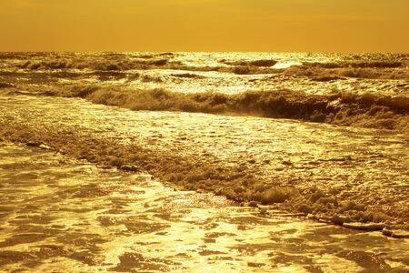 the sun rises above the waves of the seaの写真素材