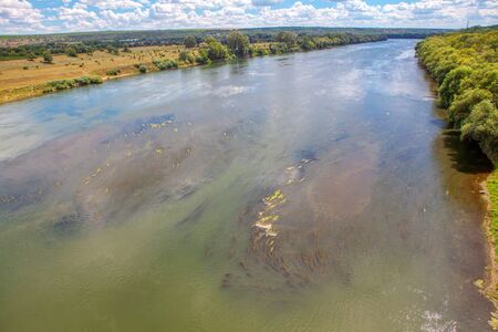 flight over the river , forest growing at the river shore