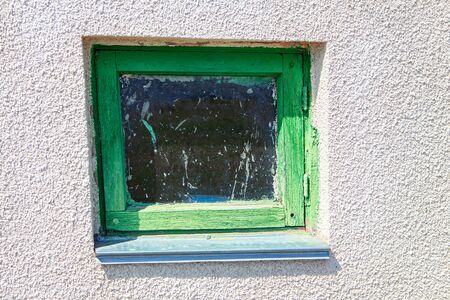 Window with green frame . Dirty window leaf of old barnの写真素材