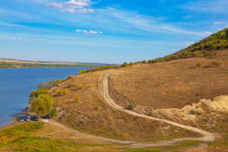 Landscape with hill and river . Country Road . Picnic by the river