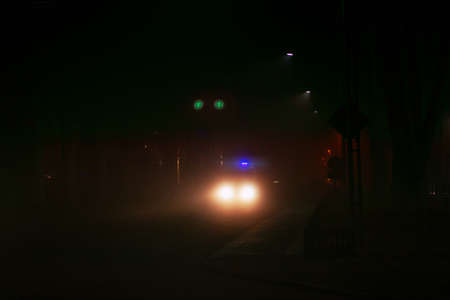 Ambulance in foggy night . Haze over the night street