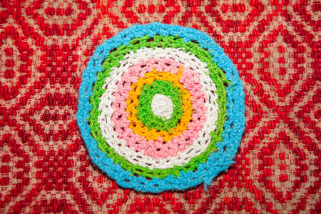 Embroidered rug in the shape of a circle . Handmade colorful carpet