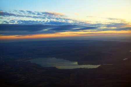 Panoramic view of lake between hills in the dusk . Aerial view of evening nature