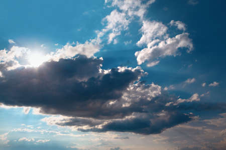 Sun Rays and Dark Clouds on Blue Sky