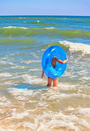 Boy with a rubber ring in the sea . Child without supervision . Dangerous swimming in stormy weather