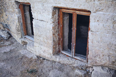 Stone wall and windows of ancient house . Antique architectural ruins