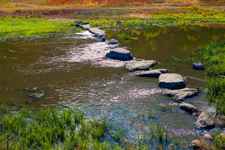 Stones in flowing water for crossing the river