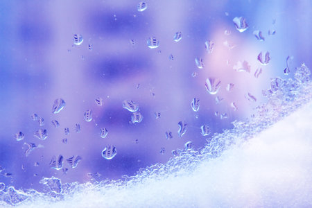 Water drops and snow on the window glass
