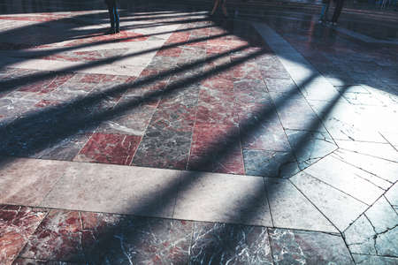 People walking on the granite pavement . Pedestrian street with shadowsの写真素材