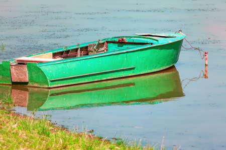 Green fishing boat moored near to the shore . Old fishing vesselの写真素材