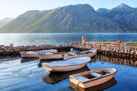 White wooden boats for fishing on the harbour . Morning Outlook of Mountains and Lagoonの写真素材