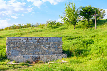 Fresh mineral water from a natural water source . Source of groundwater . Cross on the hill near water springの写真素材