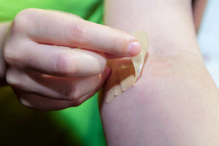Removing adhesive bandage from the hand