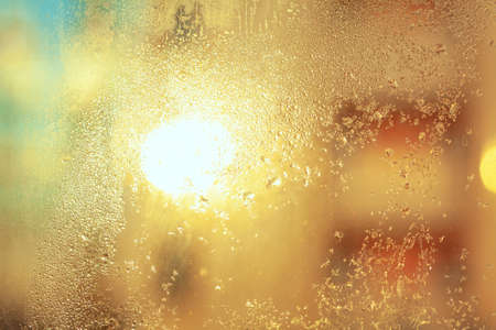 Sun glowing in frost surface . Frozen drops on the glass