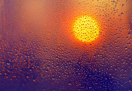 Sun and water drops on the glass . Sunset in the rainの写真素材