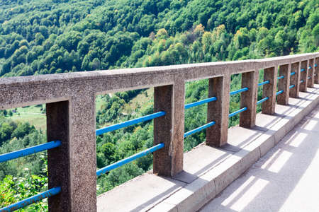 Balustrade of The Durdevica Tara Bridge in Montenegro . Green forest treetops view from the bridgeの写真素材
