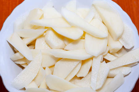 Chopped raw potatoes in the plate , ready for fryingの写真素材