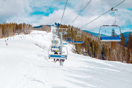 Ski slope resort . Ski Lift Connection . Snowy mountains and forestの写真素材