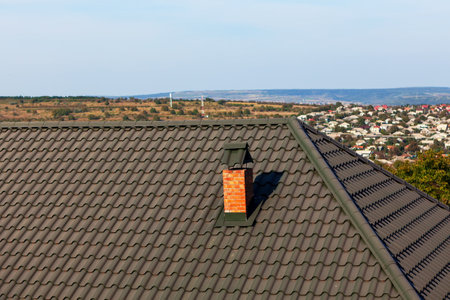 Chimney at the metal tile roof . Rooftop of rural houseの写真素材