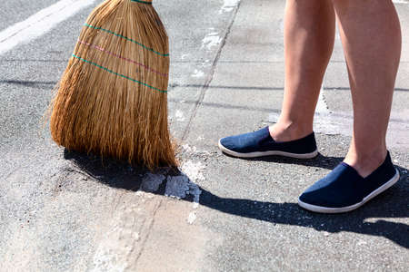 Exterior Cleaning with Corn Broom . Courtyard floor sweeping . Feet and corn broomの写真素材