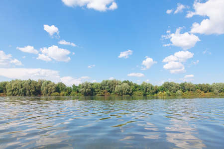 Tropical shore with green trees seen from water surface