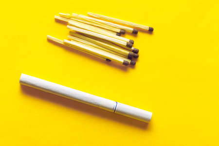 Filter cigarette with matches at yellow backgroundの写真素材