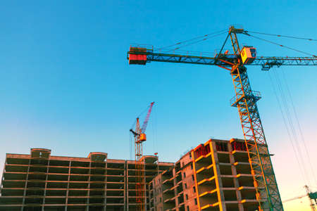 Construction site with cranes . Tower crane at unfinished urban house
